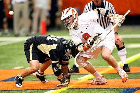 Syracuse University's Jake Moulton flipping the ball out during a faceoff with Army's Sean Reppard. 
